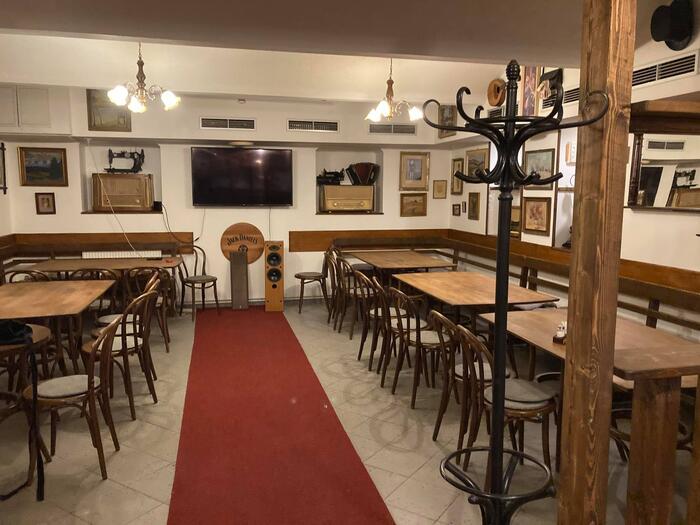 Sál s dlouhými stoly a červeným kobercem